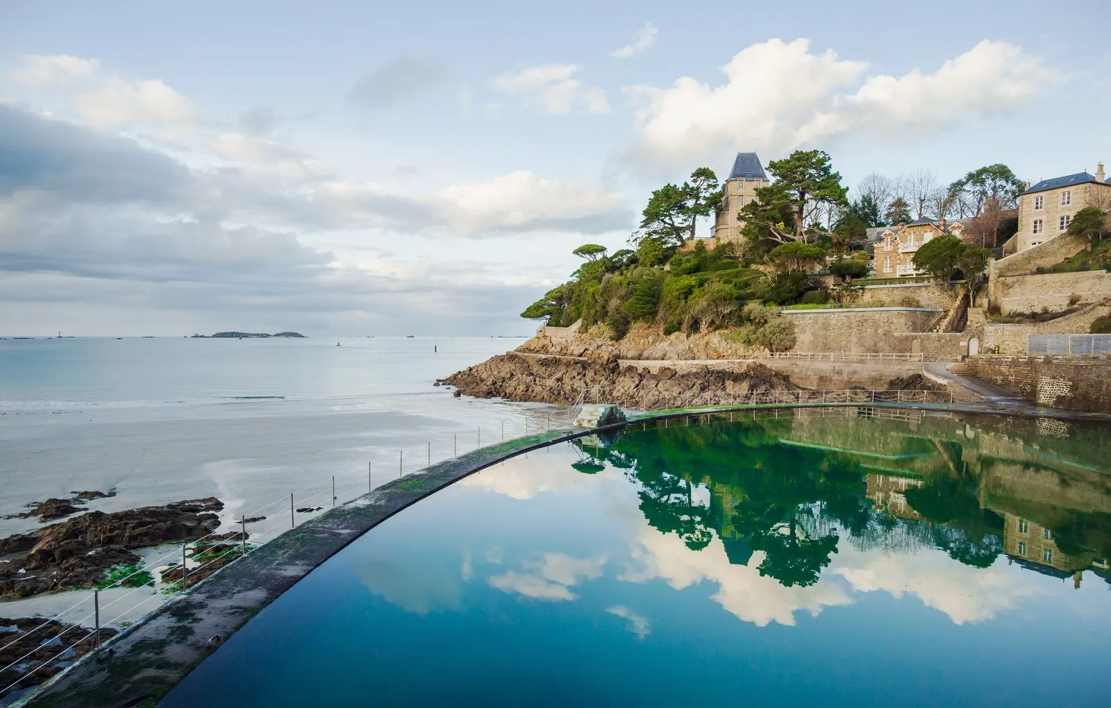 La piscine d'eau de mer de la plage de l'Écluse et les villas de la pointe du Moulinet