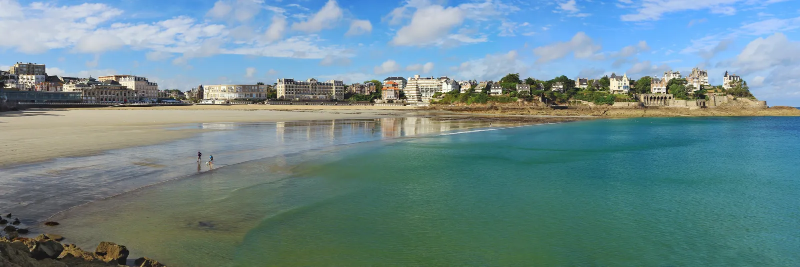 La plage de l’Écluse à Dinard en panorama, à marée basse, bordée de villas et d’hôtels