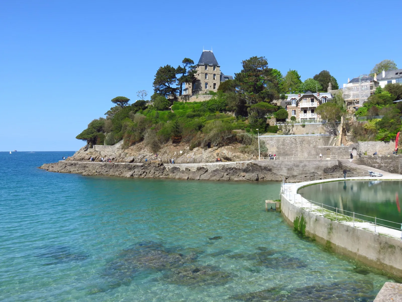 Les villas de la pointe du Moulinet à Dinard, entre les pins, au-dessus de l’eau turquoise et d’un bassin d’eau de mer