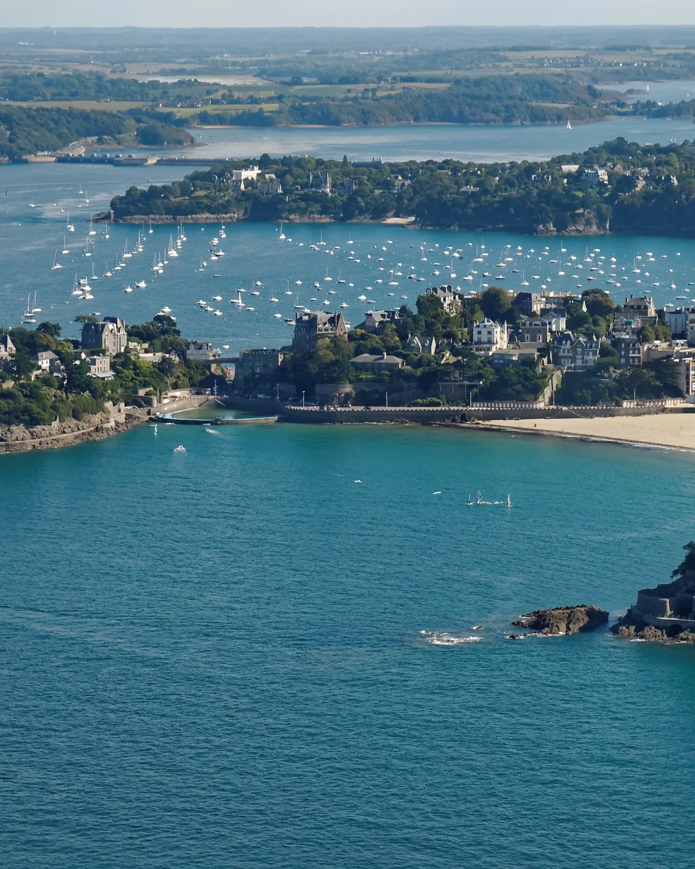 Dinard vue du ciel : ses pointes boisées, ses plages et l’estuaire de la Rance couvert de voiliers au mouillage