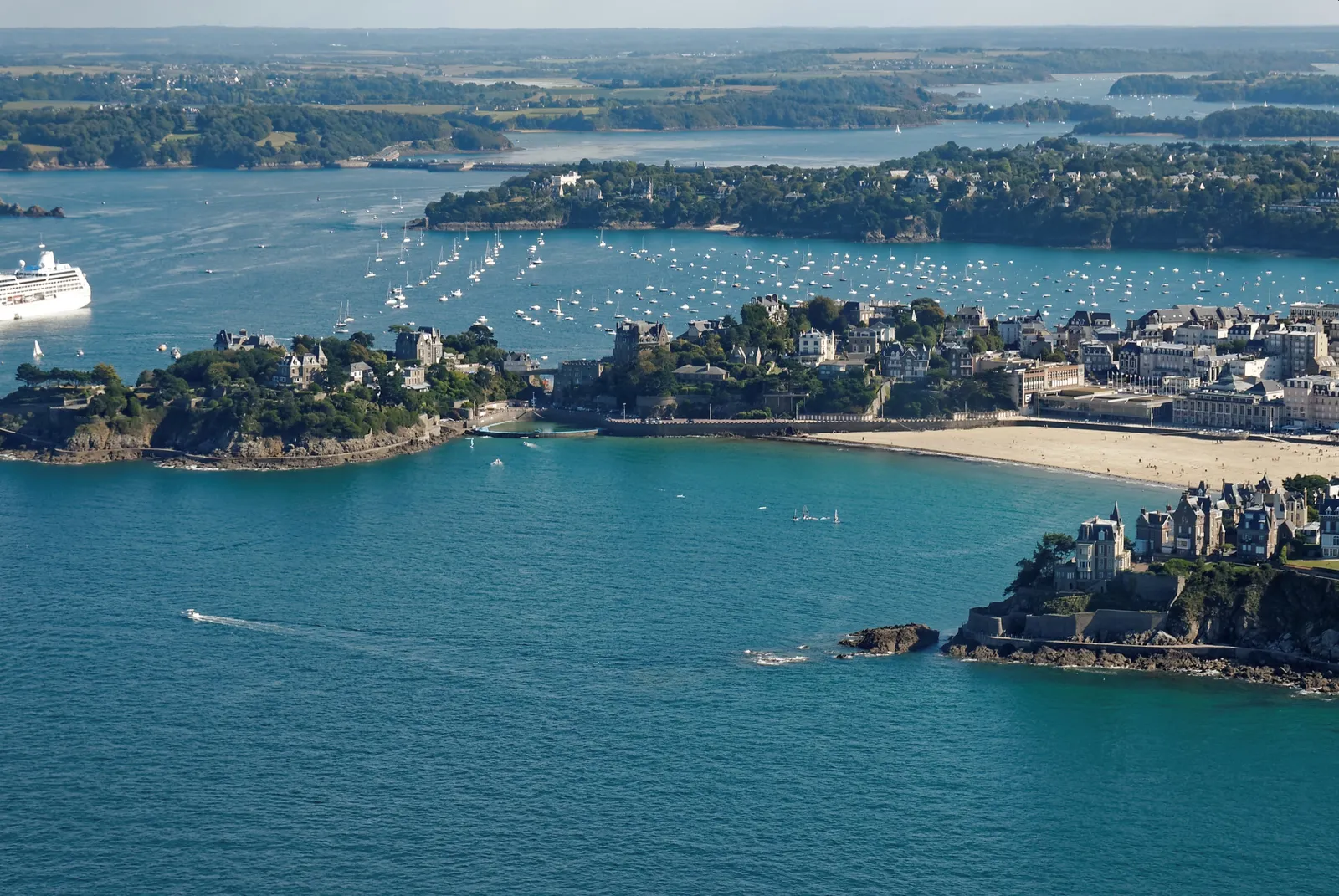 Dinard vue du ciel : ses pointes boisées, ses plages et l’estuaire de la Rance couvert de voiliers au mouillage