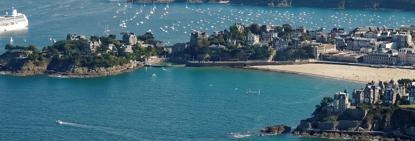 Dinard vue du ciel : ses pointes boisées, ses plages et l’estuaire de la Rance couvert de voiliers au mouillage