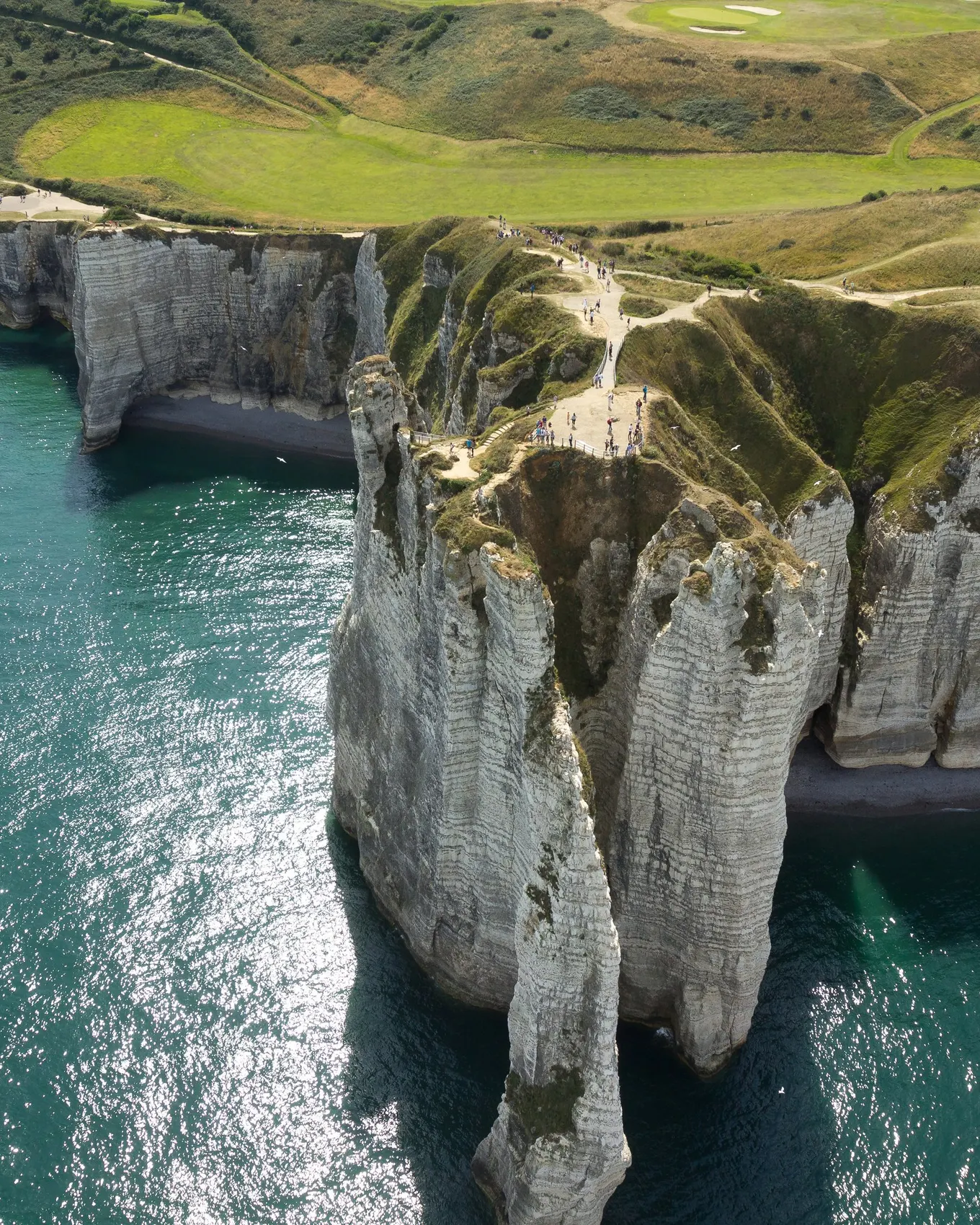 Les falaises d’Étretat et l’Aiguille vues du ciel, la mer turquoise et les prairies du plateau