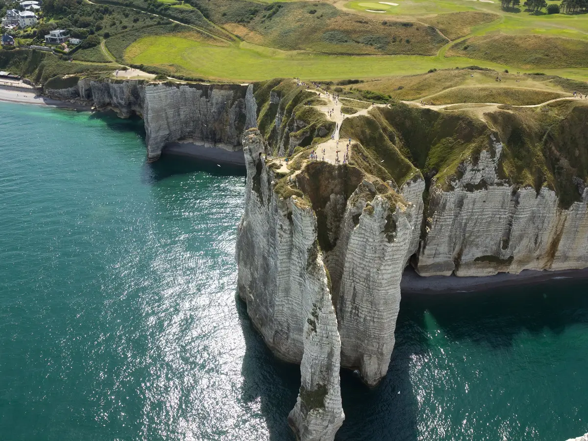 Les falaises d’Étretat et l’Aiguille vues du ciel, la mer turquoise et les prairies du plateau