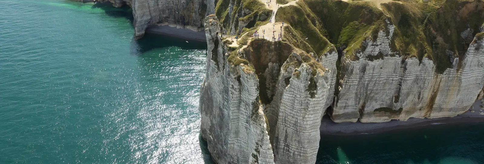 Les falaises d’Étretat et l’Aiguille vues du ciel, la mer turquoise et les prairies du plateau