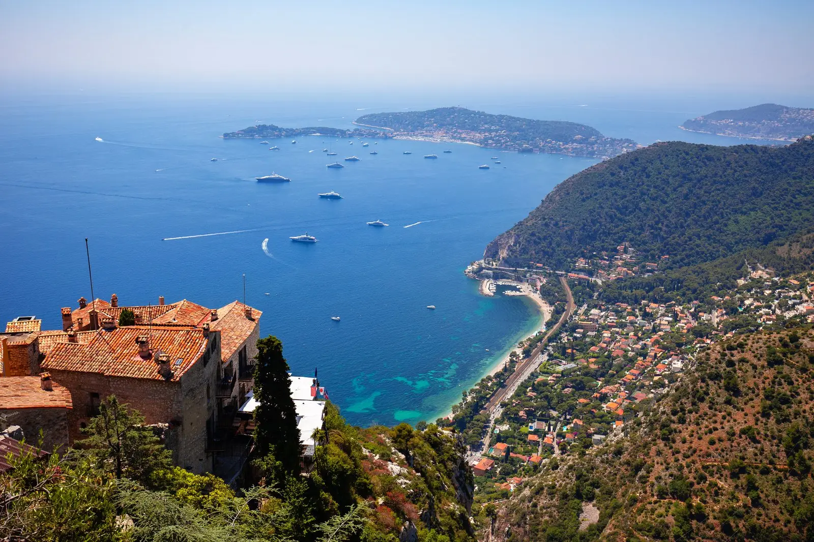 La baie d’Èze vue du village, les toits de tuiles au premier plan et le cap Ferrat au loin