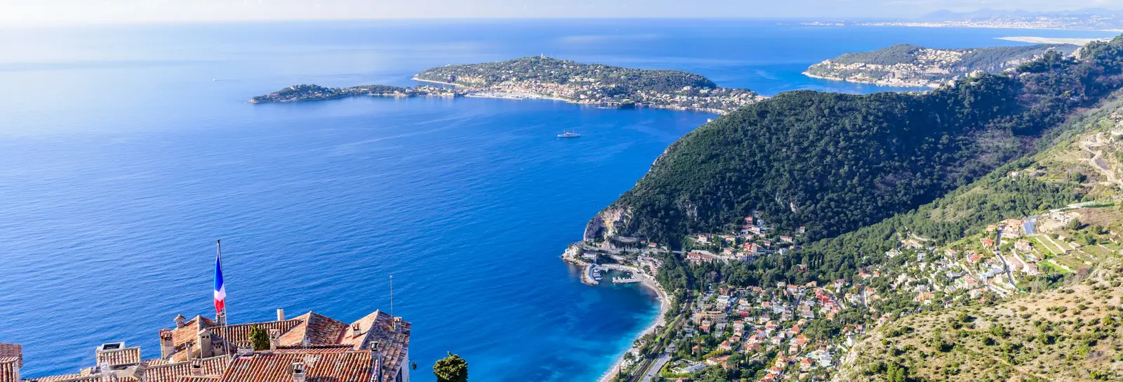 Èze village visto do alto: os seus telhados de pedra sobre o Mediterrâneo e a costa e os seus cabos no horizonte