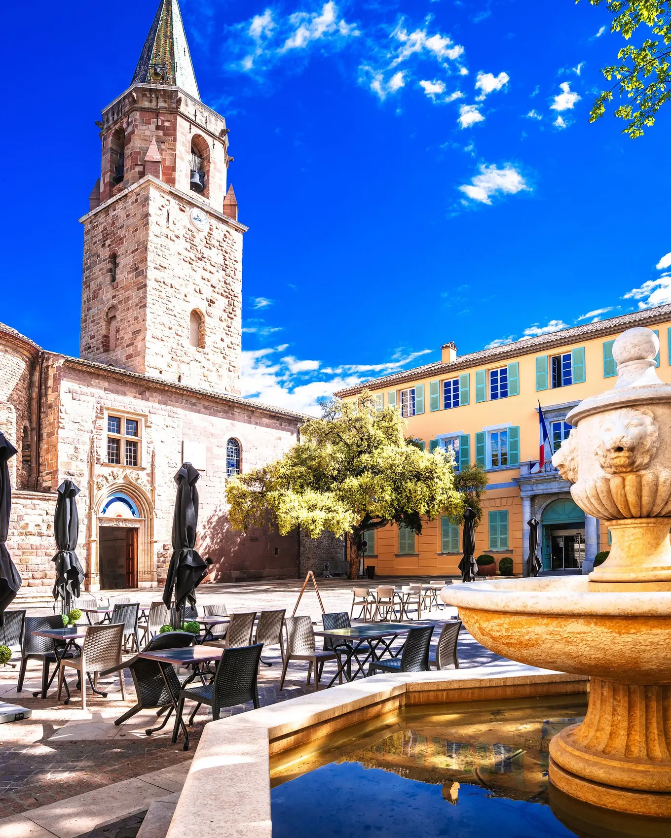 La place de la cathédrale et sa fontaine dans le vieux Fréjus, le clocher et une façade jaune aux volets turquoise