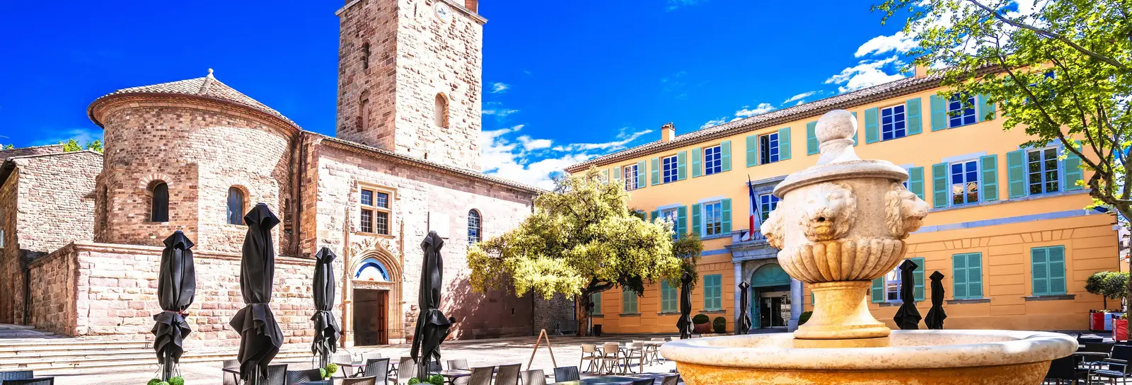 La place de la cathédrale et sa fontaine dans le vieux Fréjus, le clocher et une façade jaune aux volets turquoise