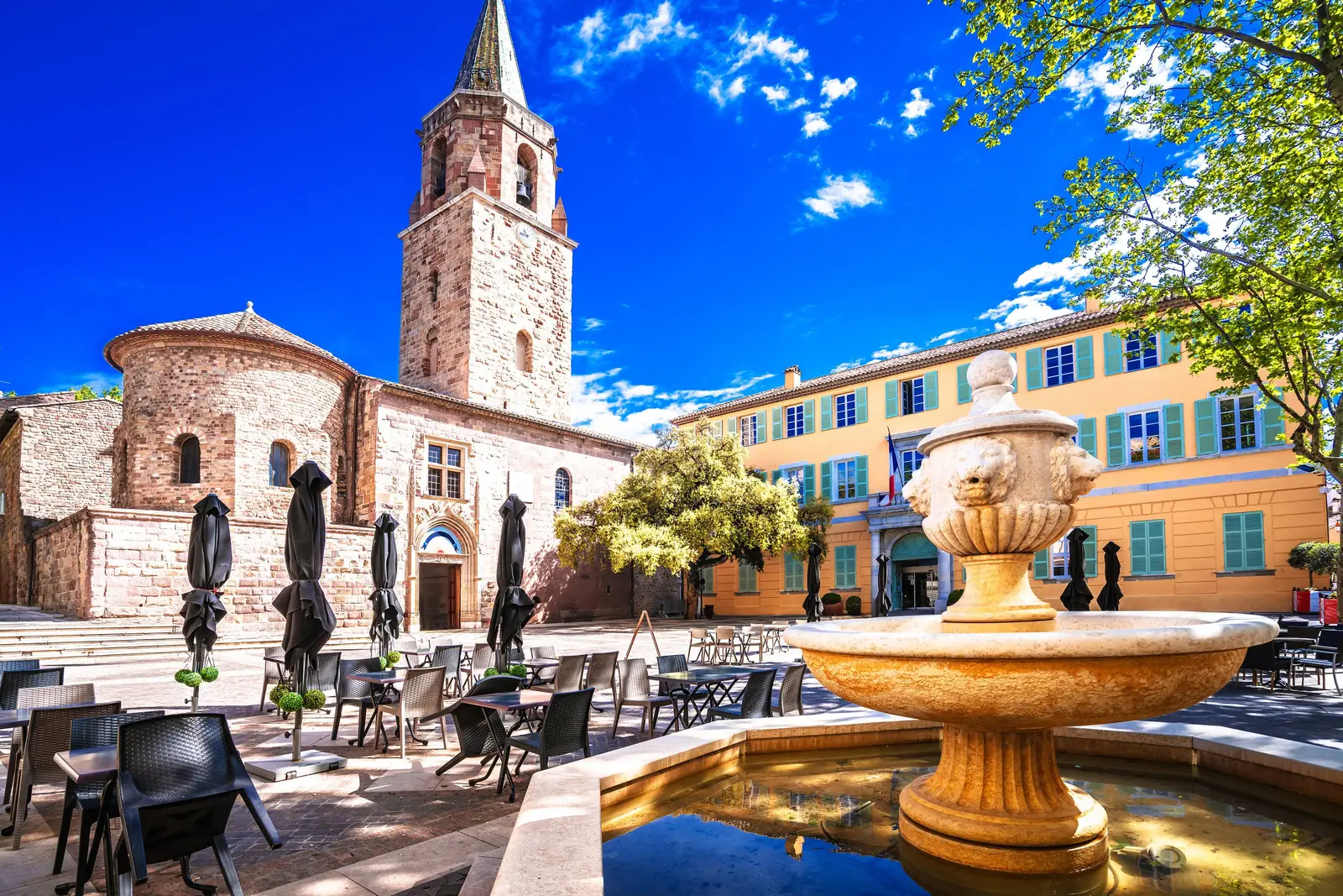 The cathedral square and its fountain in old Fréjus, the bell tower and a yellow façade with turquoise shutters