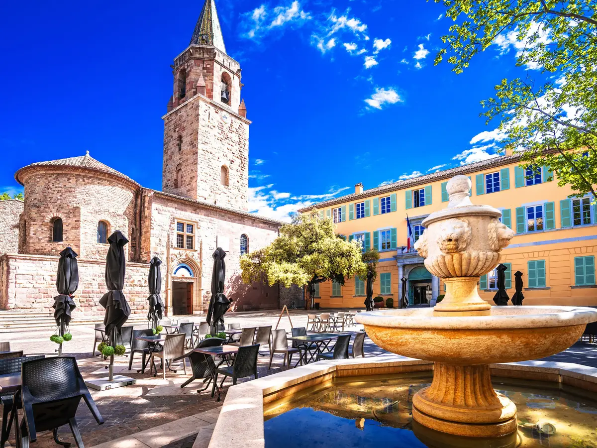 La place de la cathédrale et sa fontaine dans le vieux Fréjus, le clocher et une façade jaune aux volets turquoise