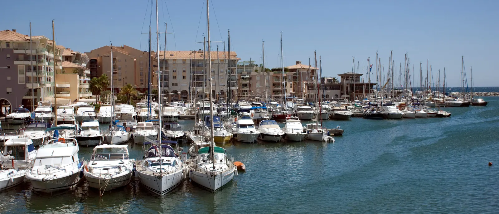 Os veleiros atracados em Port-Fréjus, diante dos edifícios da marina de Fréjus
