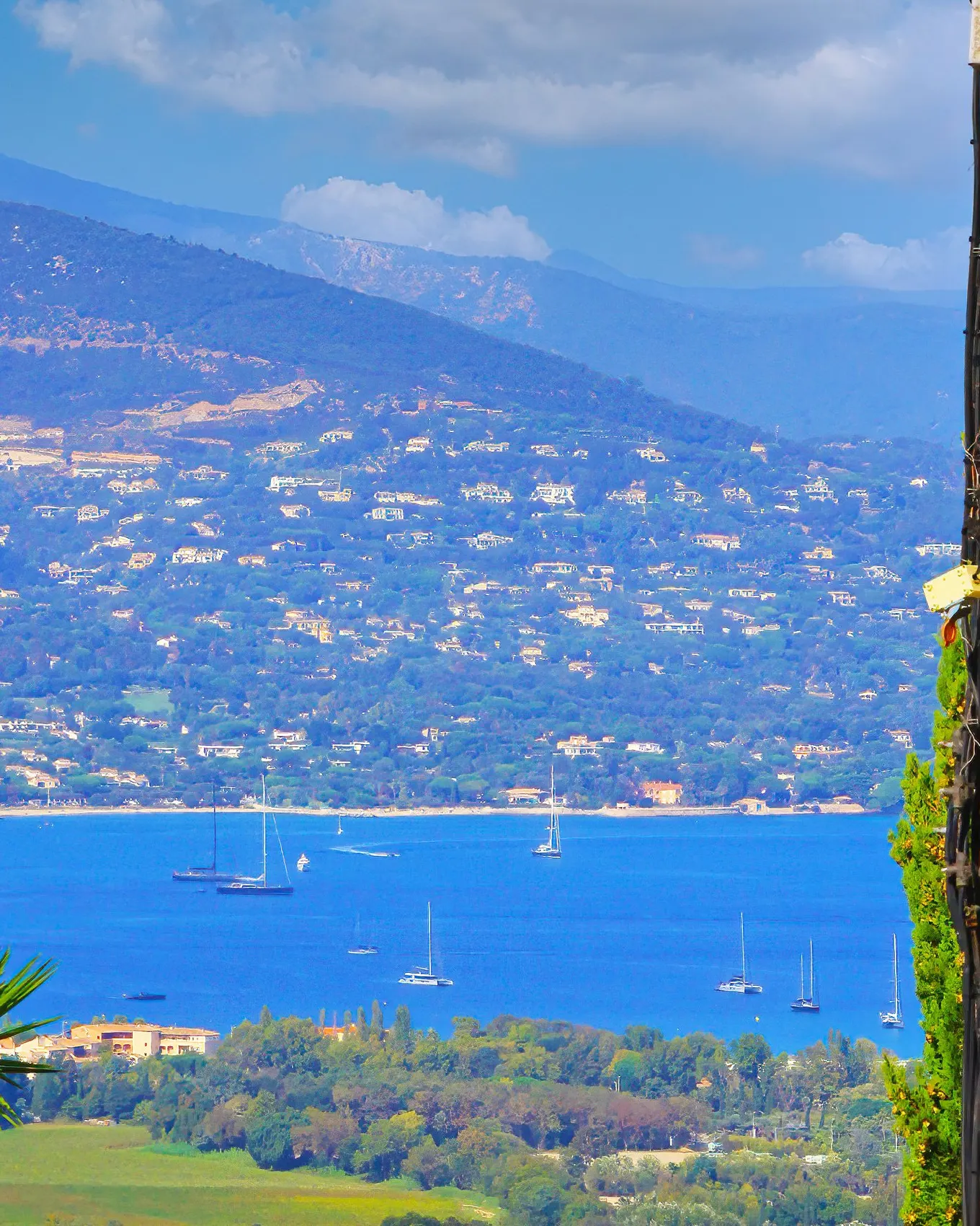 A lane in the hilltop village of Gassin and, below, the Gulf of Saint-Tropez with its yachts and its hills dotted with villas