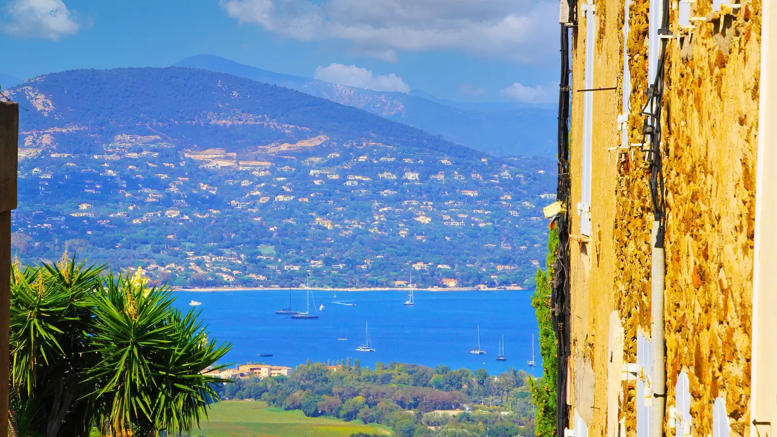 A lane in the hilltop village of Gassin and, below, the Gulf of Saint-Tropez with its yachts and its hills dotted with villas