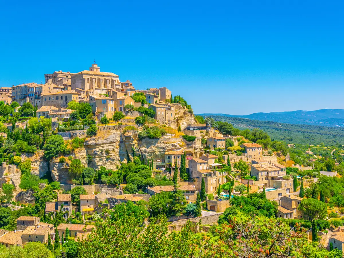 Gordes accroché à son rocher, ses maisons de pierre étagées sous le château et l’église, face au Luberon