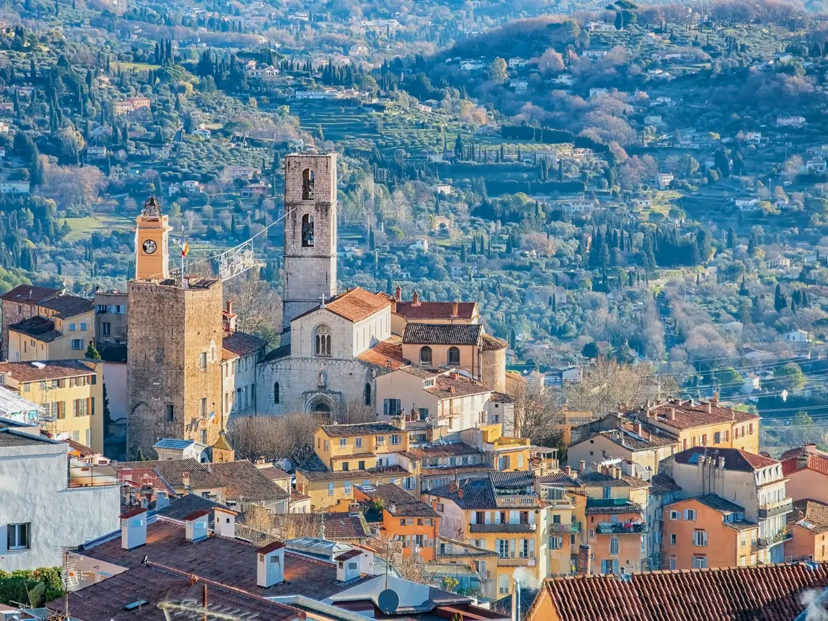 A cidade velha de Grasse e a catedral de Notre-Dame-du-Puy, diante das colinas salpicadas de villas, oliveiras e ciprestes