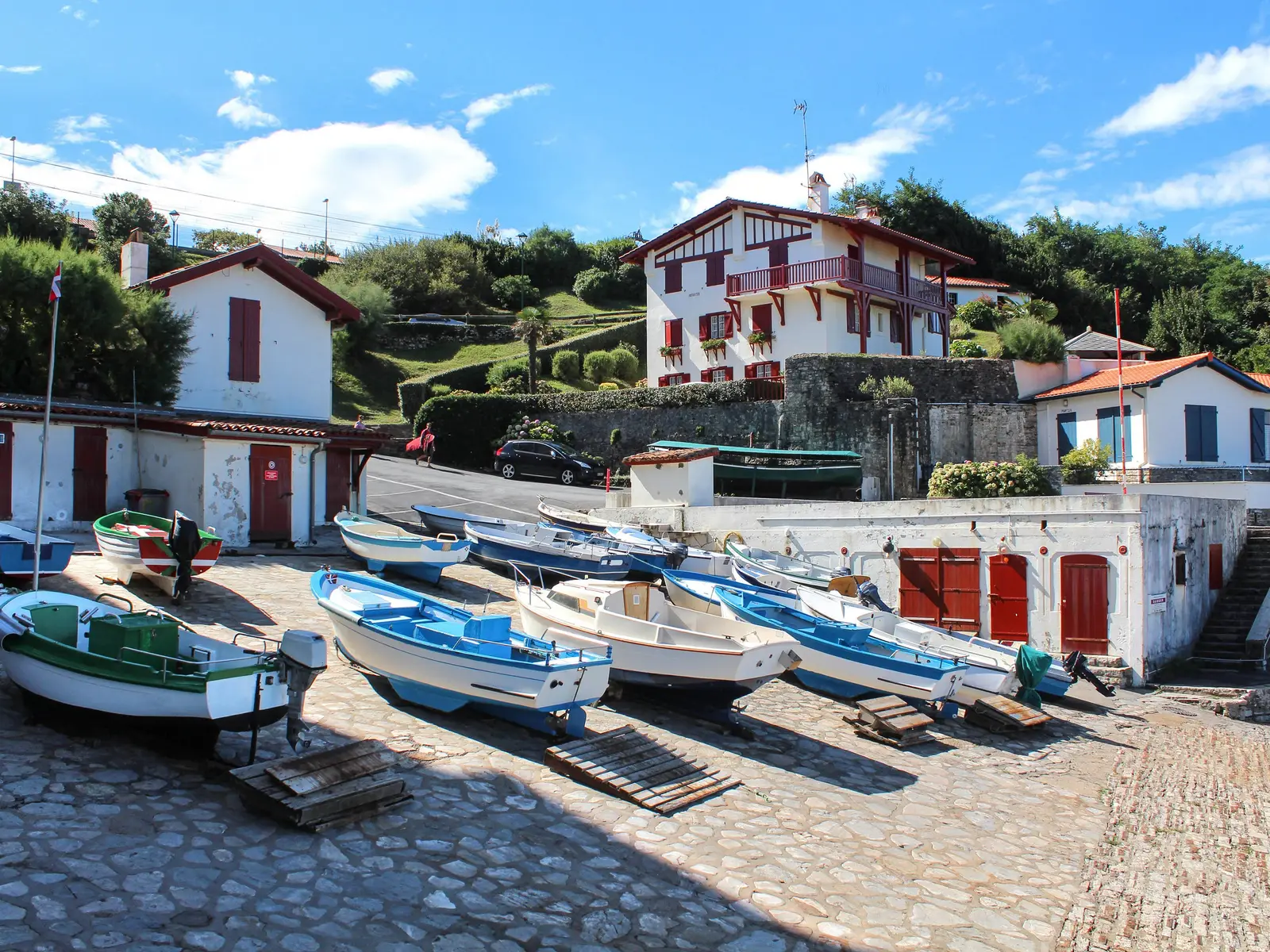 O porto de Guéthary, os seus barcos puxados para a rampa e as casas bascas brancas de portadas vermelhas