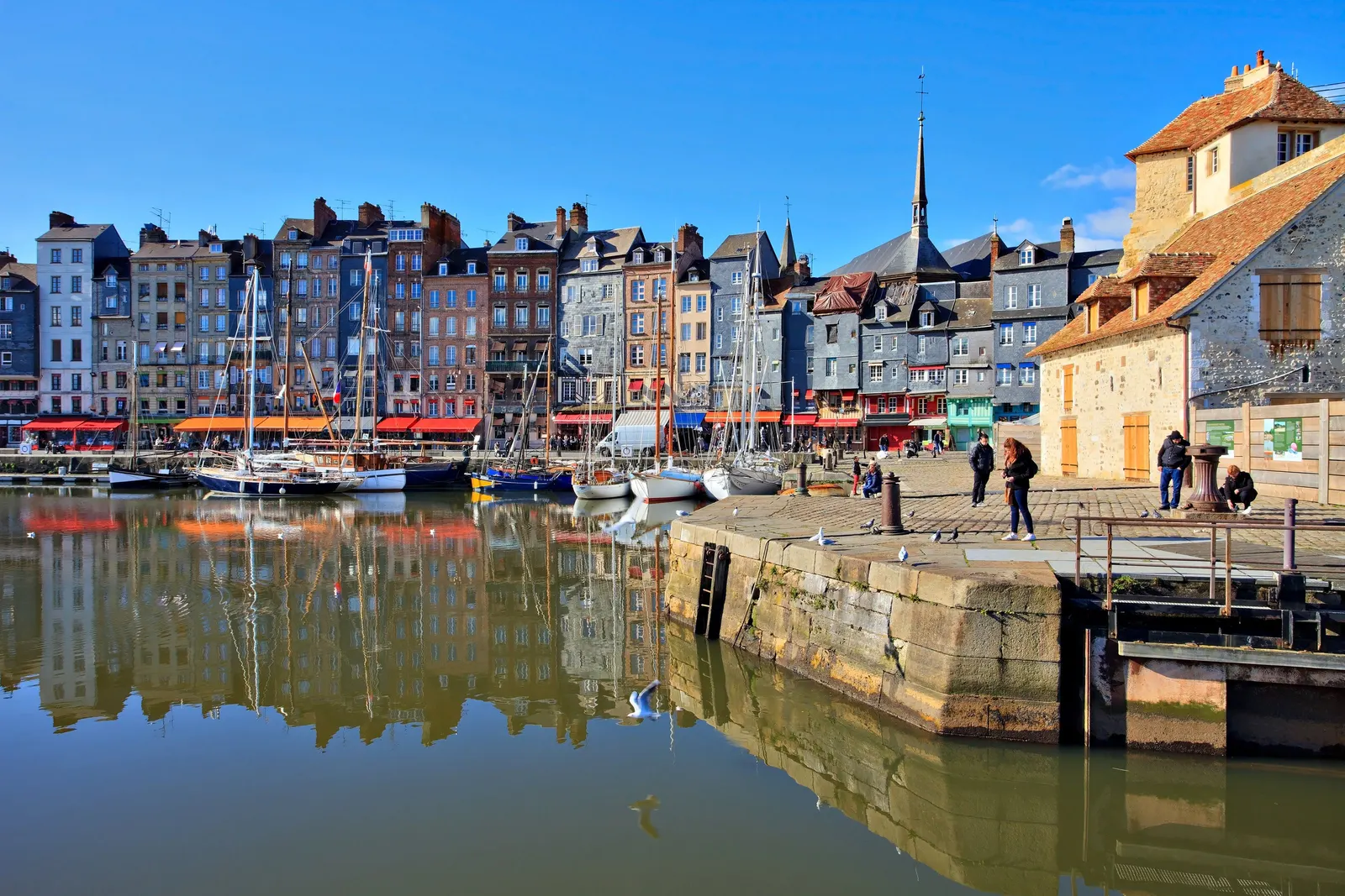 Le Vieux-Bassin de Honfleur, ses hautes maisons étroites aux façades d’ardoise et de couleur, et leurs reflets dans l’eau