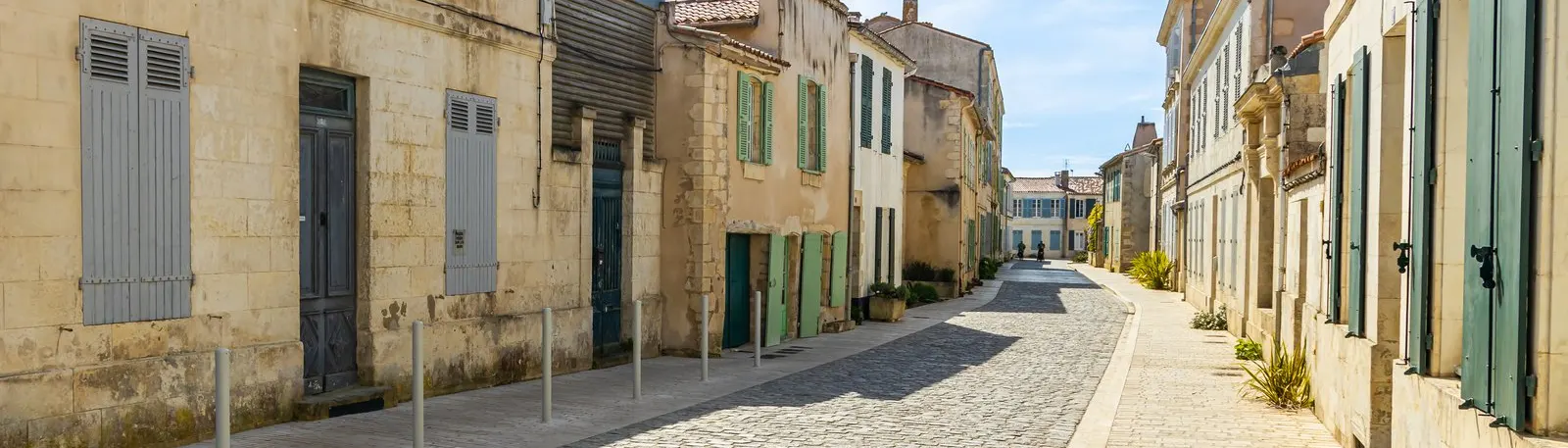 Uma rua de Saint-Martin-de-Ré, com portadas verdes e muros de pedra