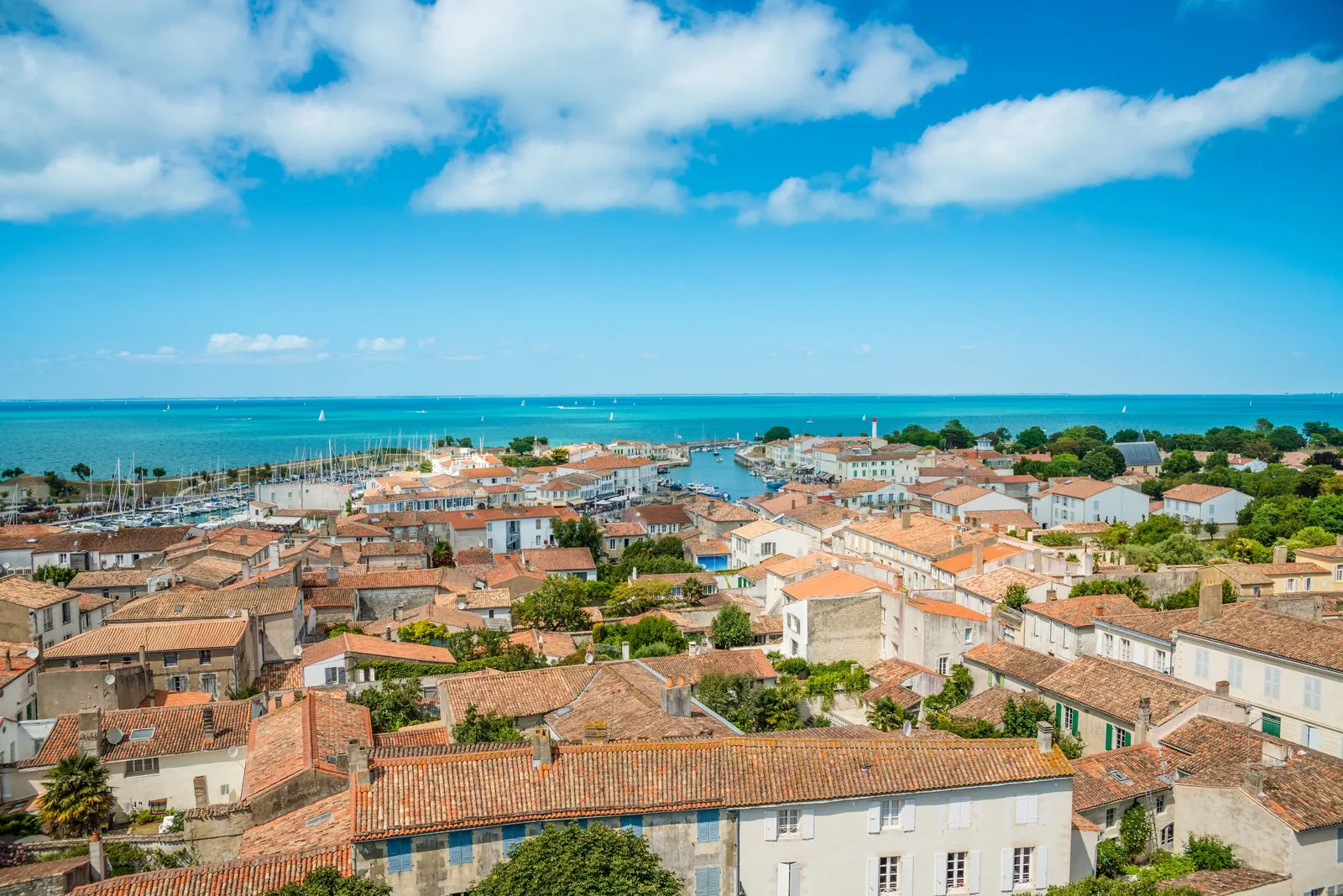 Os telhados de telha de Saint-Martin-de-Ré, o porto e o oceano