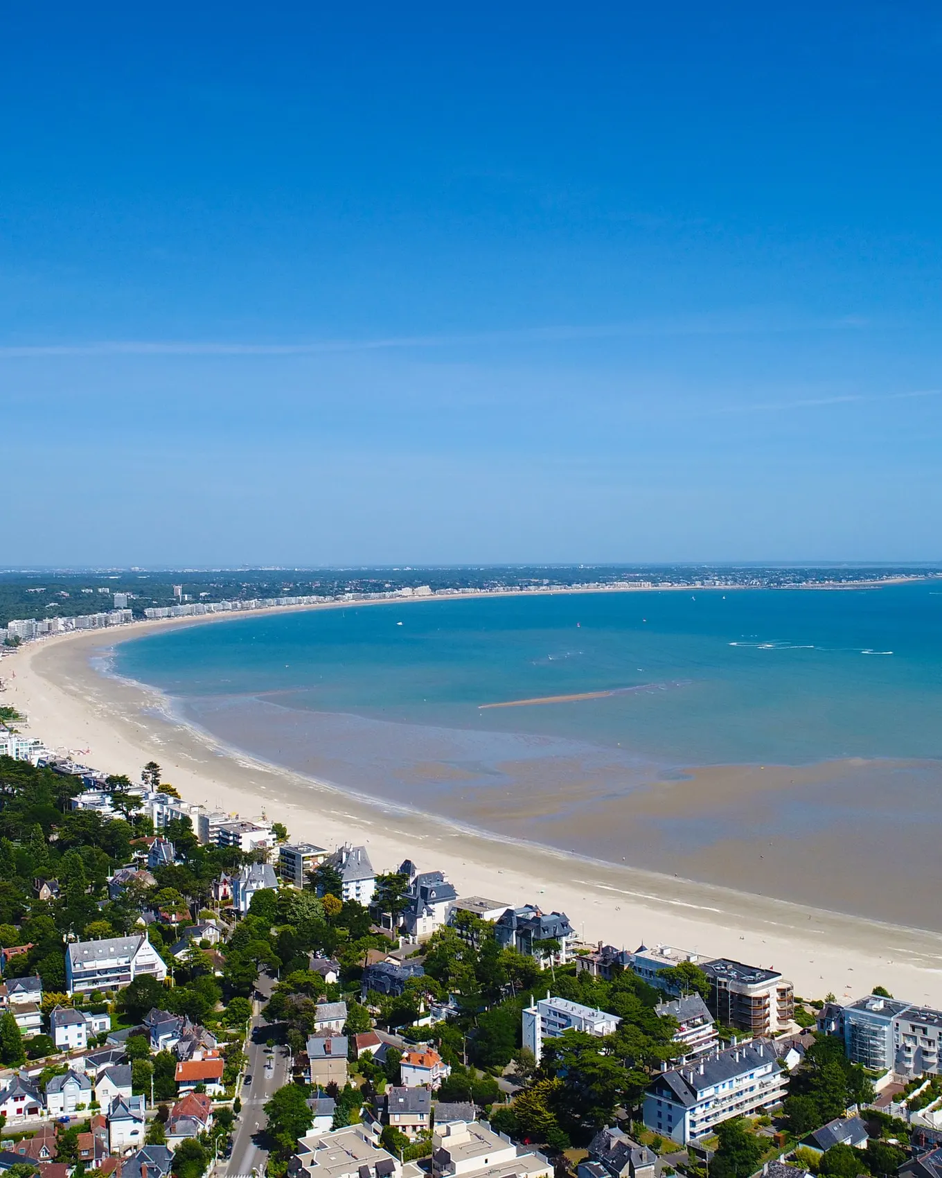 La baie de La Baule vue du ciel : la plage en arc de cercle, les villas sous les pins et la mer à marée basse