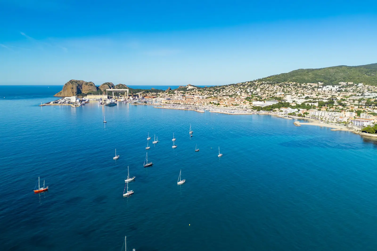 La baie de La Ciotat vue du ciel, ses voiliers au mouillage, la ville et le Bec de l’Aigle au bout