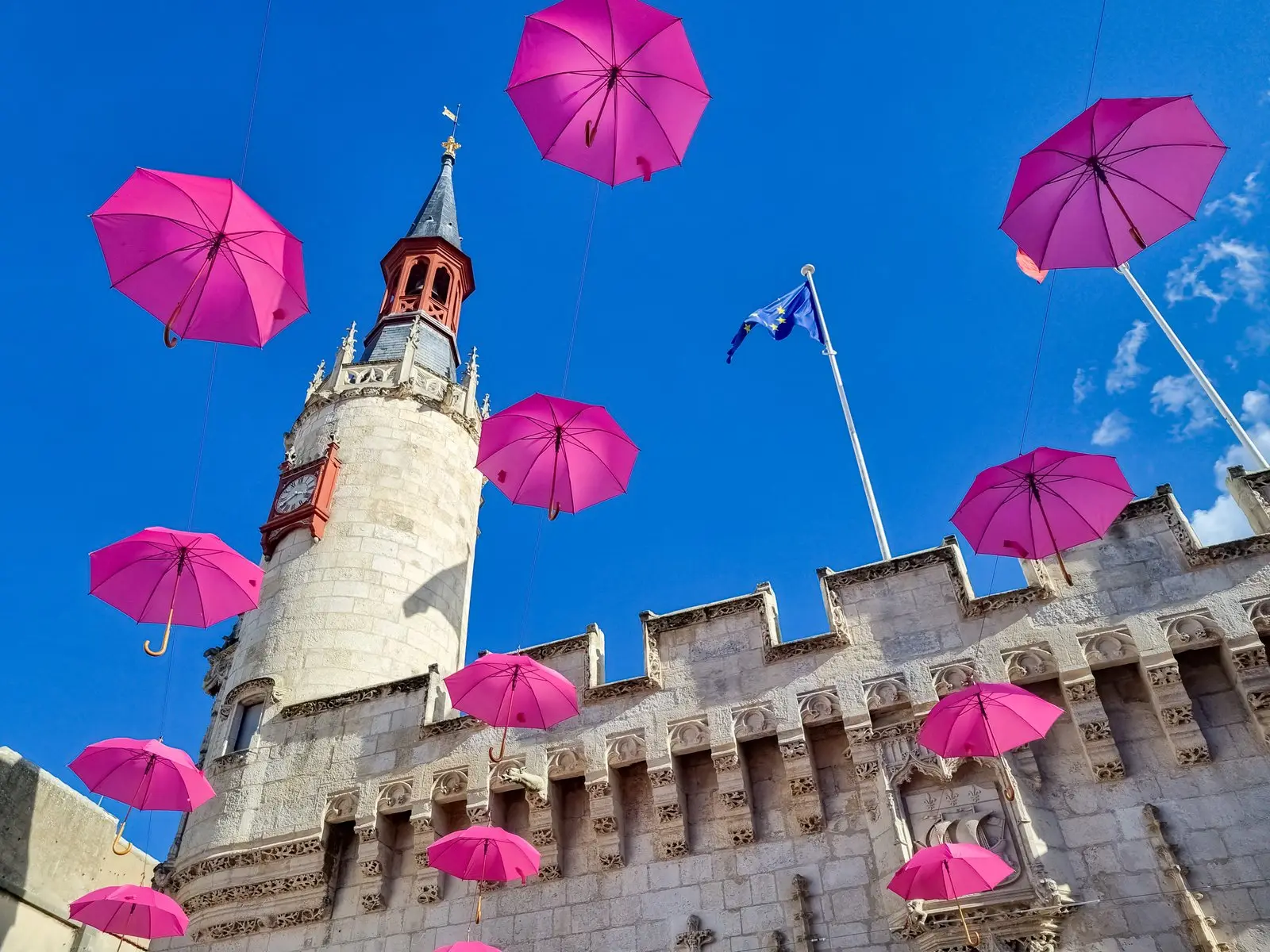 La Grosse Horloge de La Rochelle sous une envolée de parapluies roses