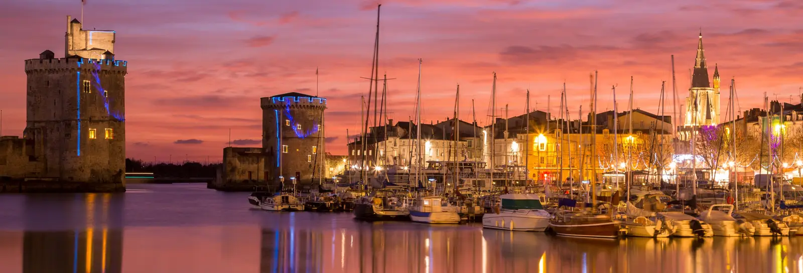 The towers of the Vieux-Port of La Rochelle at dusk and the masts of the moored yachts