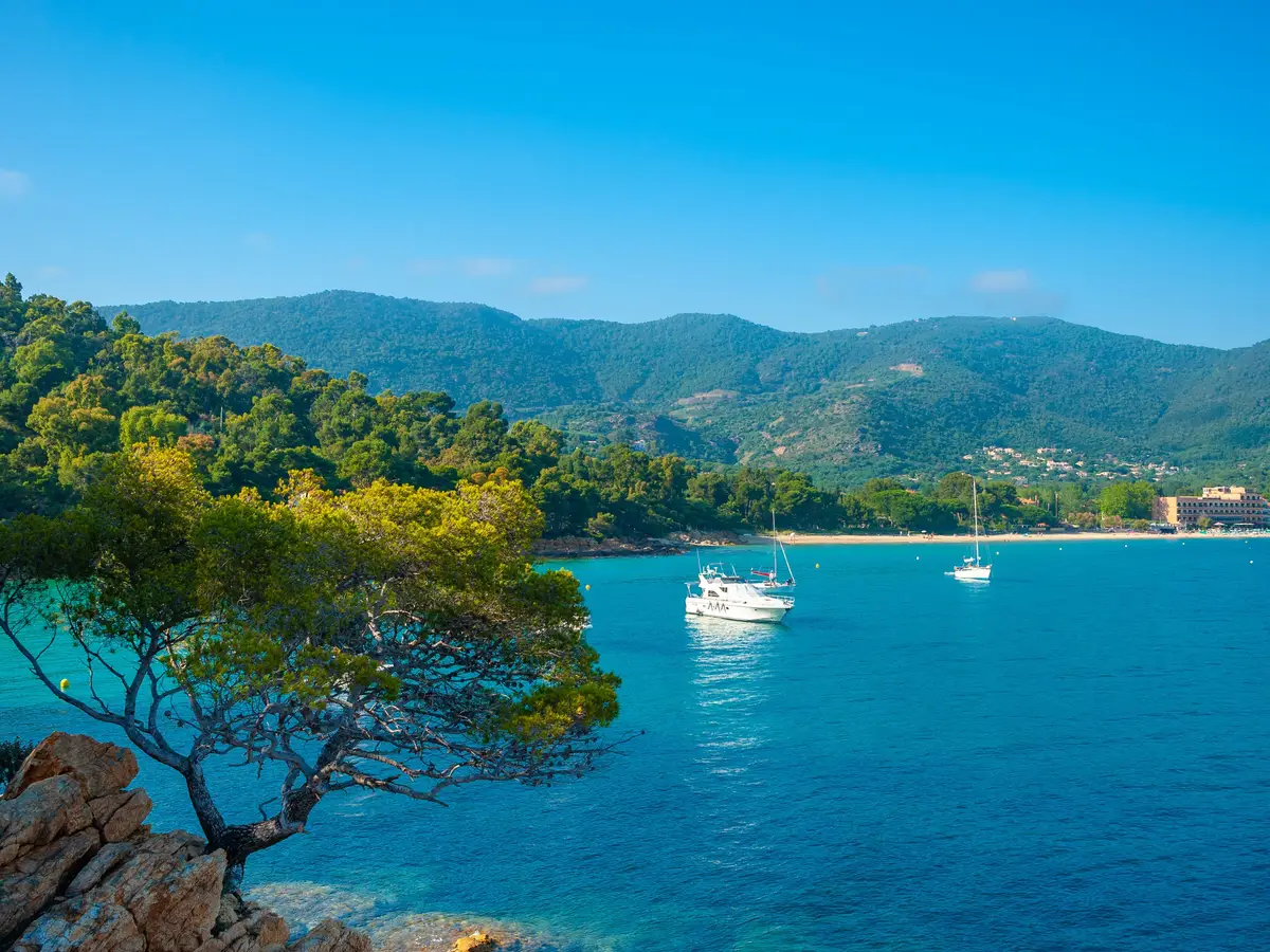 The Layet coast in Le Lavandou: turquoise sea, boats at anchor and the Maures hills