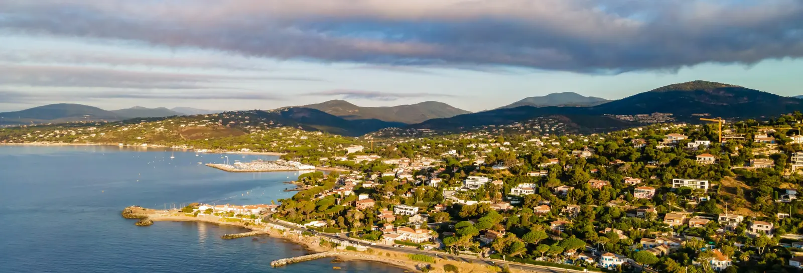 The coast of Les Issambres from the air: villas among the pines above the sea, the gulf beyond