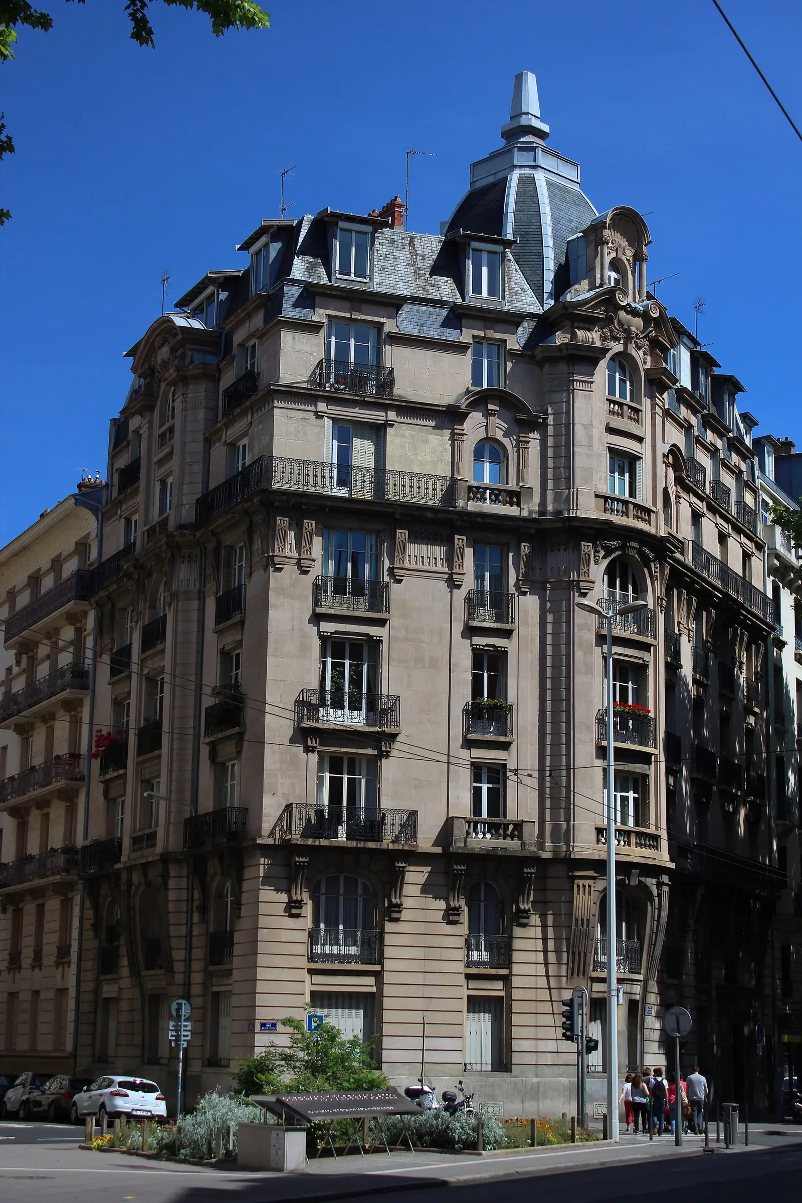 Immeuble d’angle du vieux Lyon, pierre claire, balcons en fer forgé et dôme d’ardoise