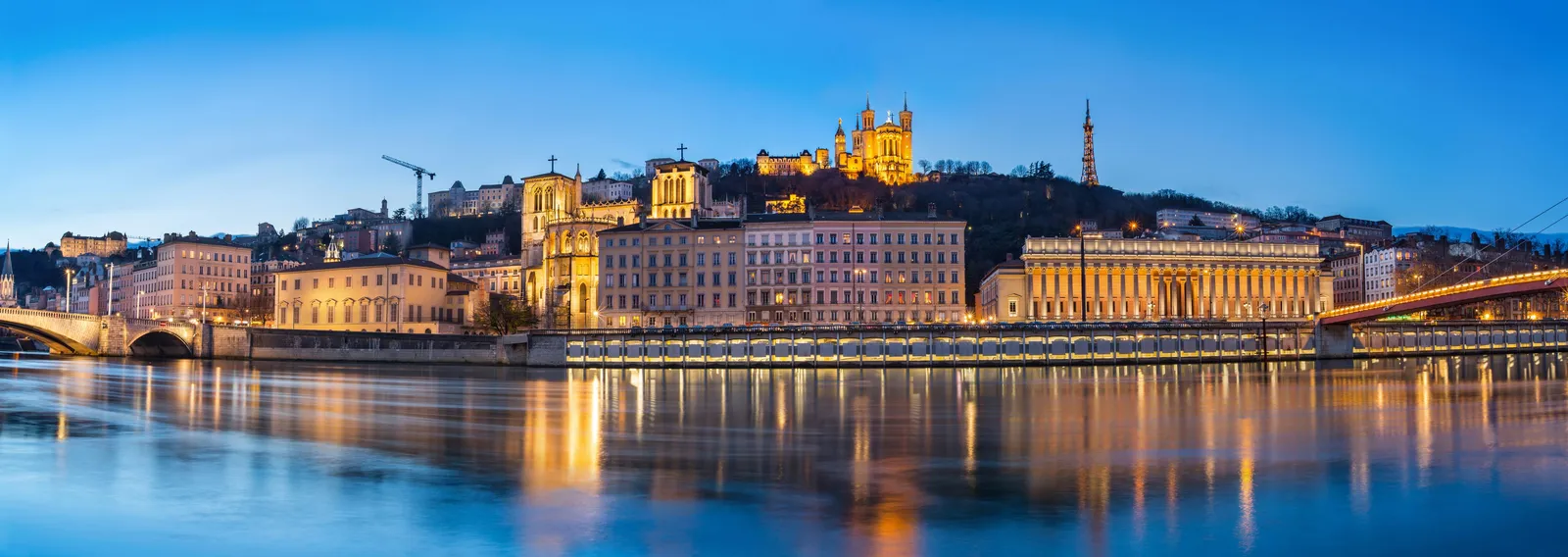 La basilique de Fourvière illuminée au-dessus de la Saône, à l’heure bleue
