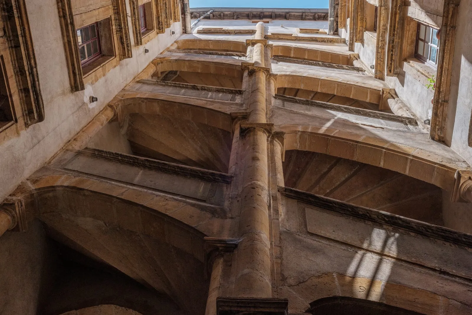 Une cour Renaissance du Vieux Lyon et son escalier à vis, vue vers le ciel
