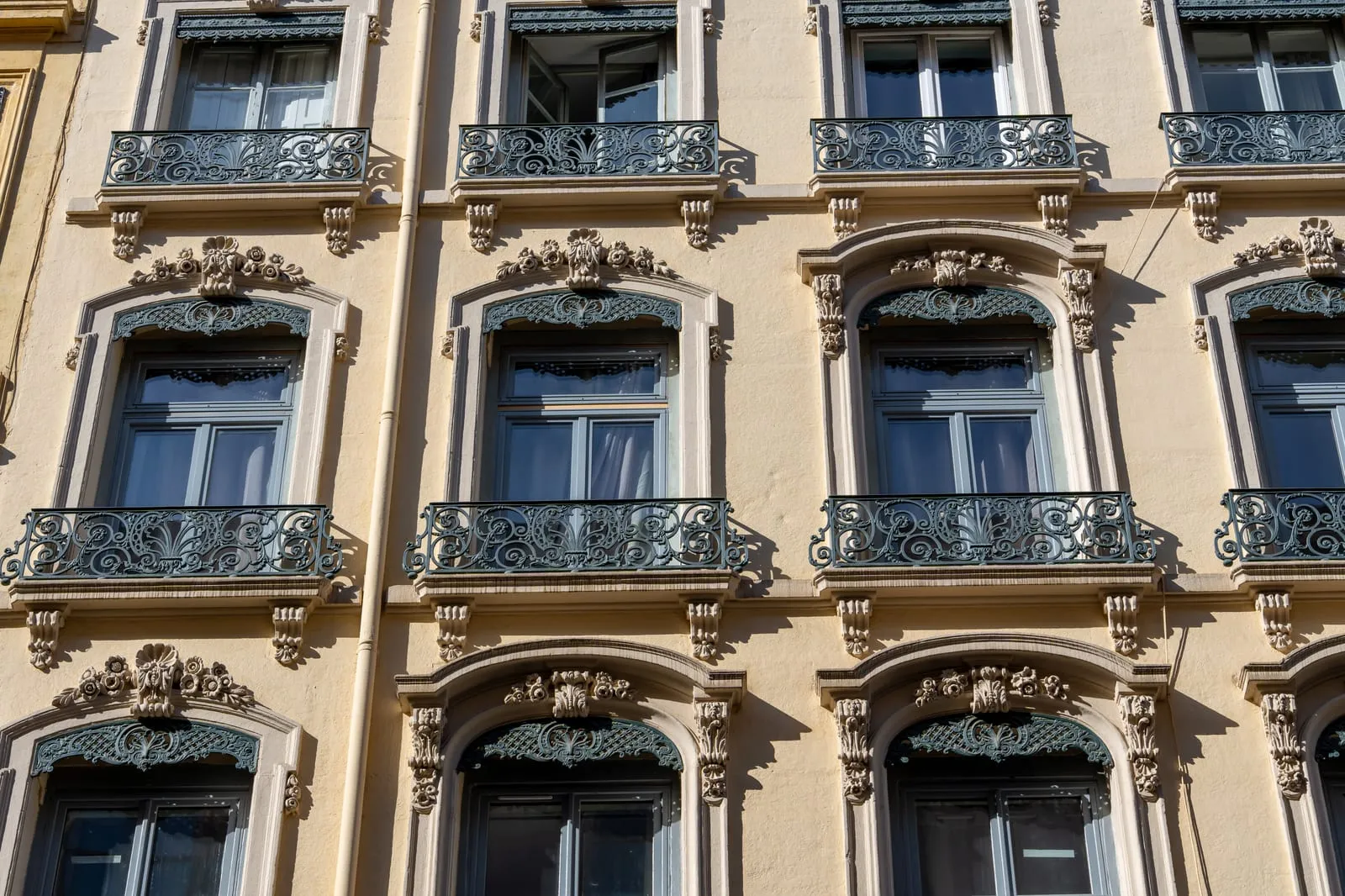 Une façade aux balcons en fer forgé dans un quartier ancien de Lyon