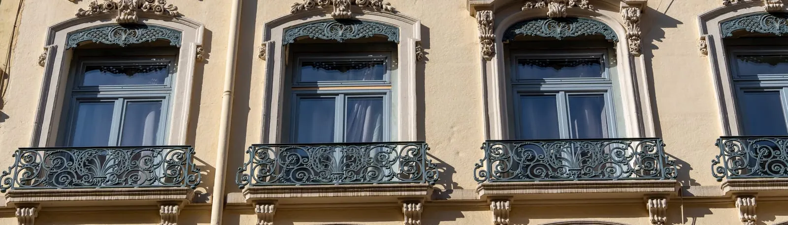 Une façade aux balcons en fer forgé dans un quartier ancien de Lyon
