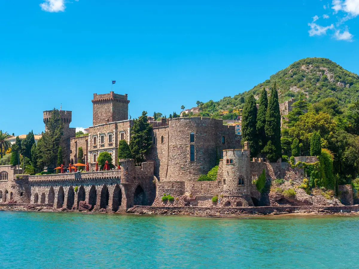Le château de La Napoule au bord de la mer, une colline boisée derrière