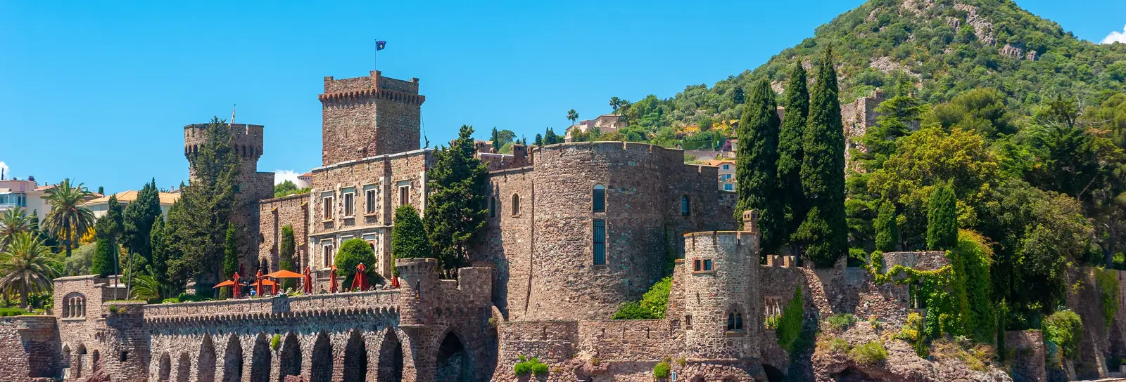Le château de La Napoule au bord de la mer, une colline boisée derrière