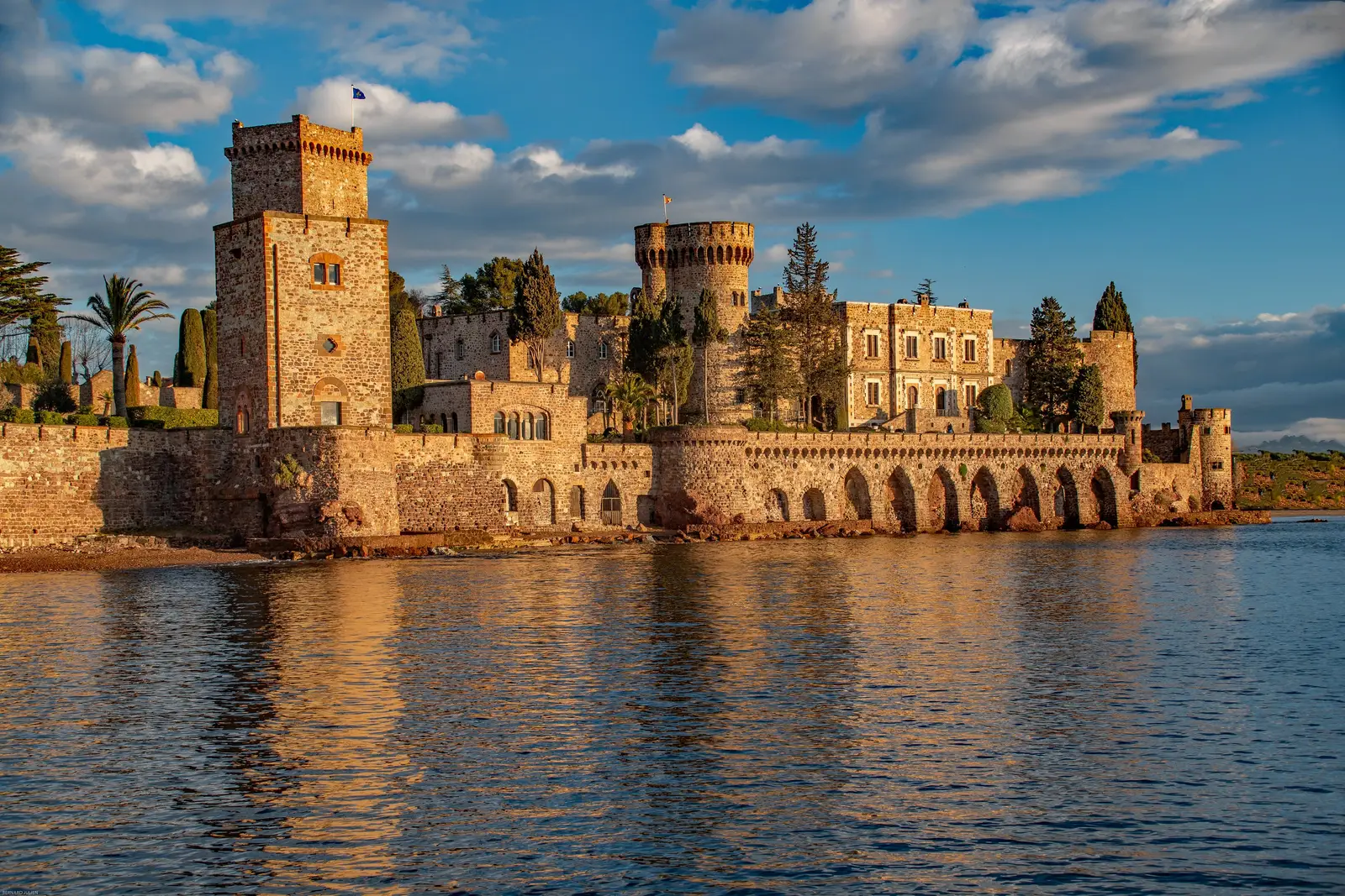 O castelo de La Napoule, em Mandelieu-la-Napoule, com as suas torres e arcadas à beira-mar na luz dourada do fim de tarde