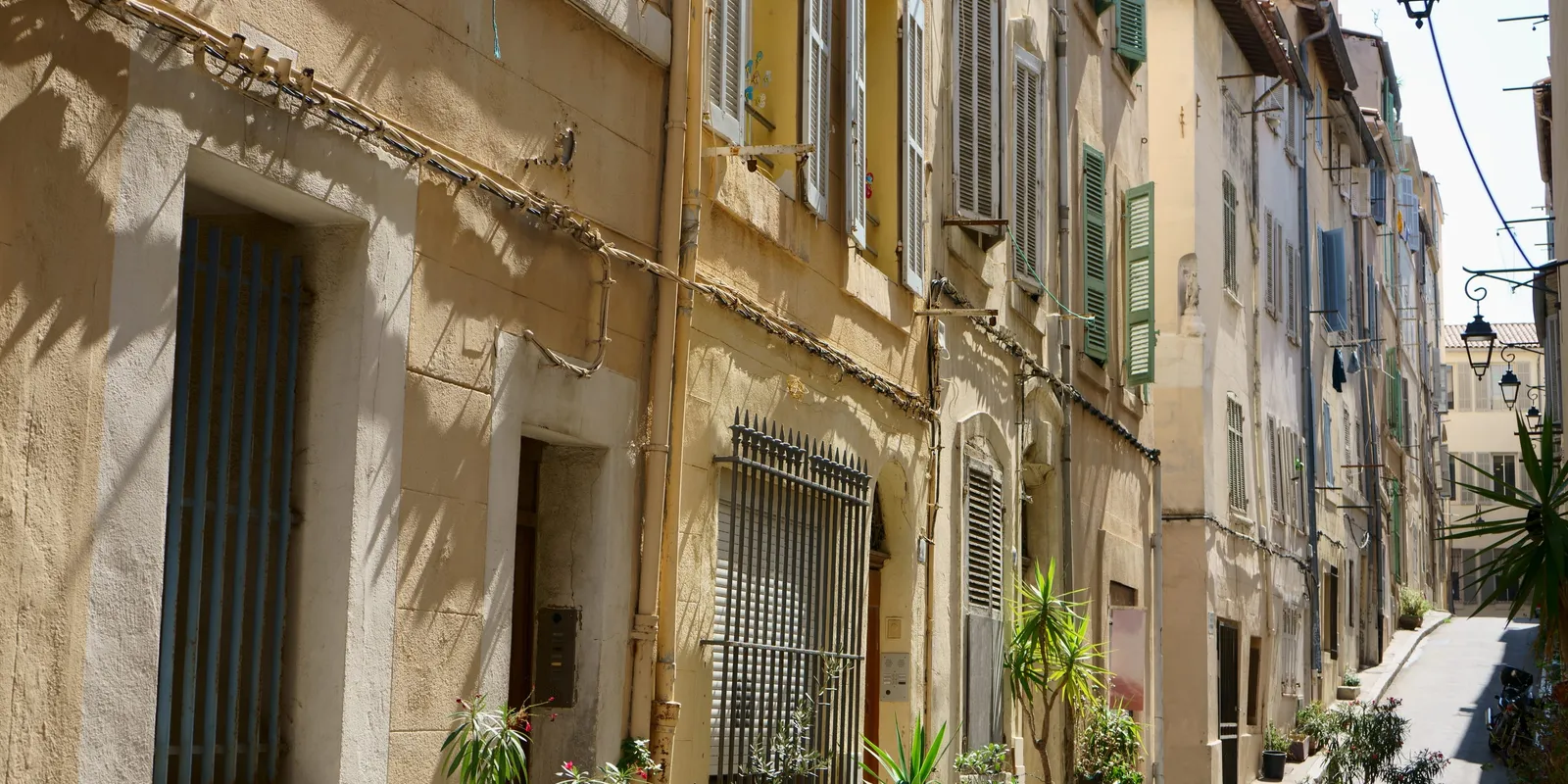 A street with pastel façades and shutters in the Panier, Marseille