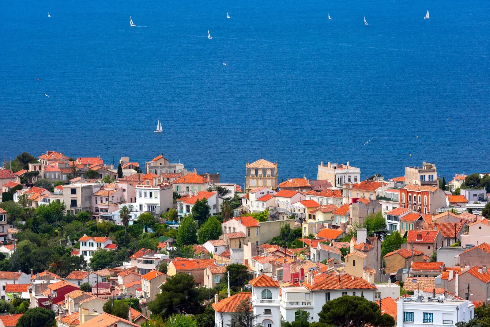 Os telhados de telha de um bairro de Marseille de frente para o mar