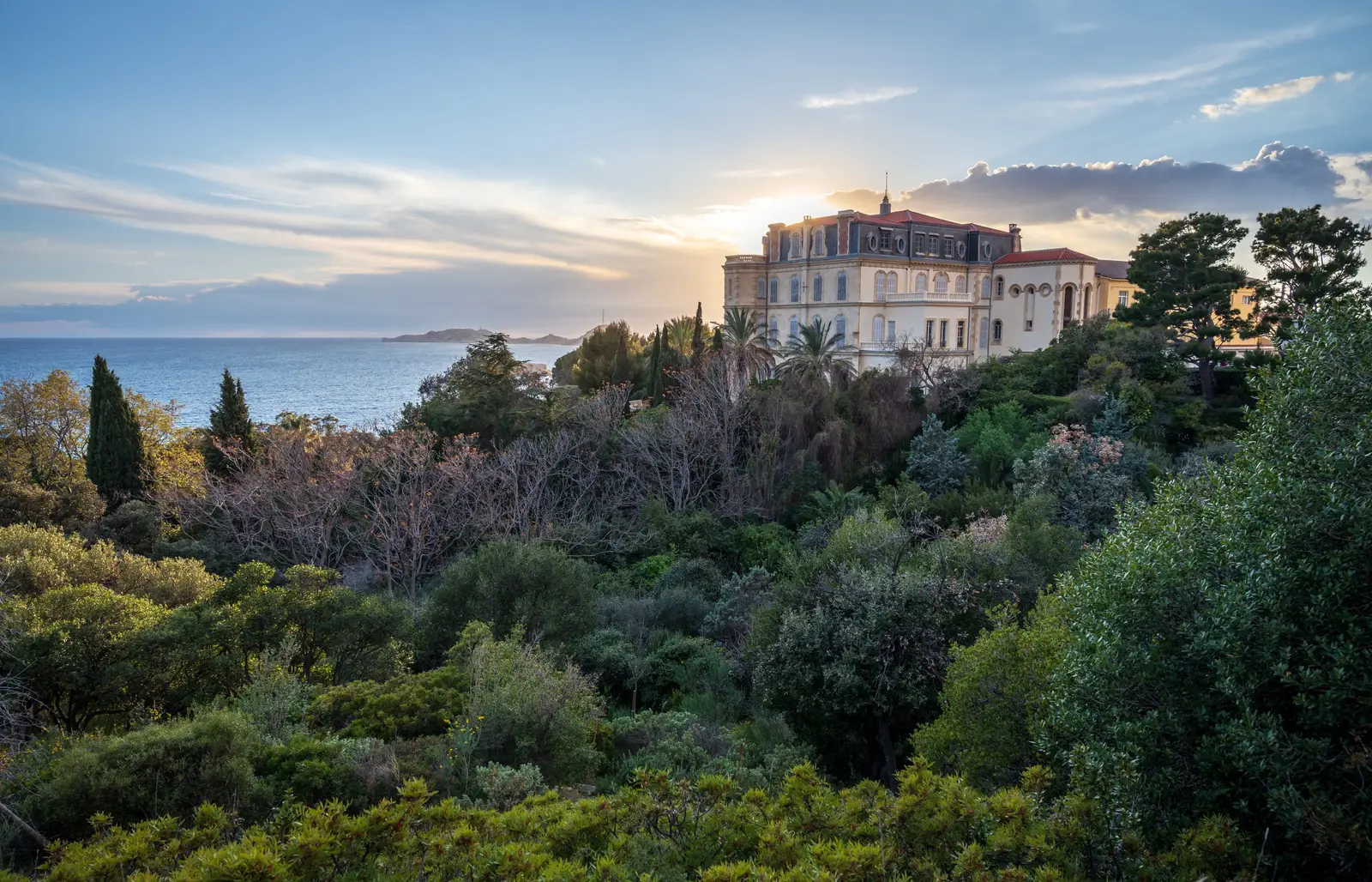 Uma grande villa da Corniche em Marselha, sobre o mar, entre pinheiros e ciprestes ao pôr do sol