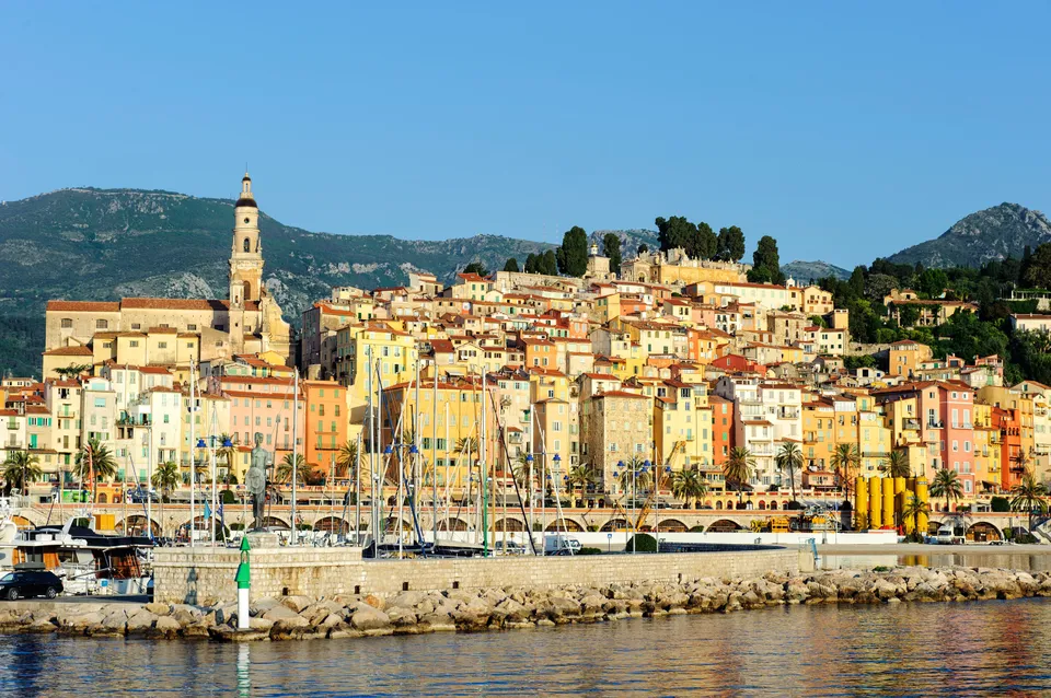 La vieille ville de Menton vue du port : ses façades ocre étagées sur la colline et le clocher de la basilique Saint-Michel