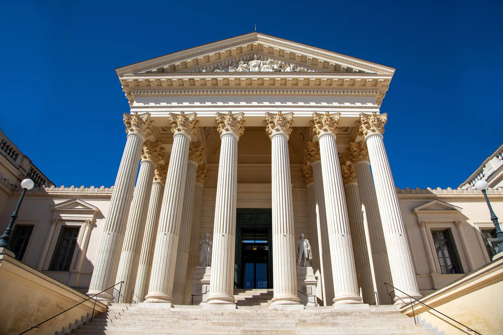 Le palais de justice de Montpellier, ses colonnes corinthiennes et son fronton sous un ciel bleu profond