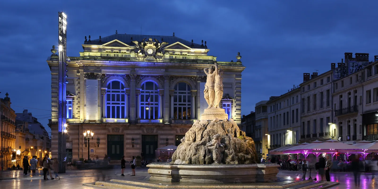 La place de la Comédie à Montpellier à l’heure bleue, l’opéra illuminé et la fontaine des Trois Grâces