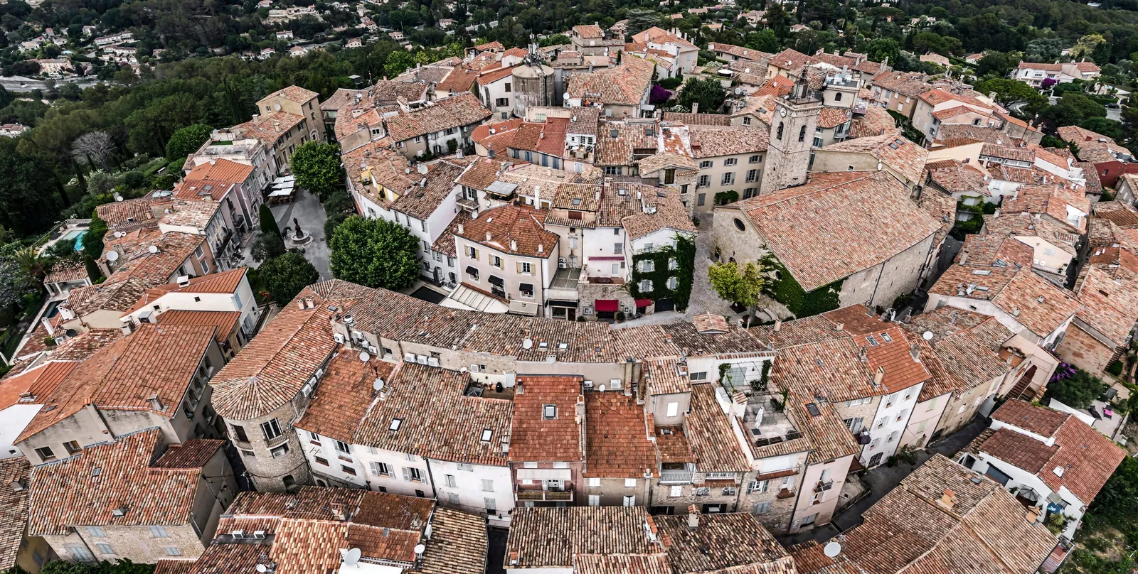 Os telhados do velho burgo de Mougins vistos do céu, as ruelas em espiral e o campanário