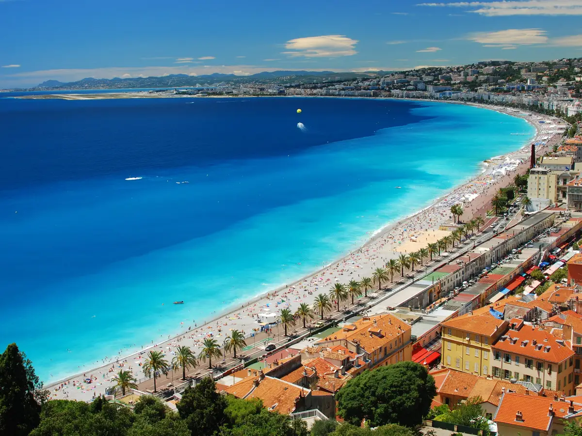 La baie des Anges et la plage de Nice vues des hauteurs de la colline du Château, la promenade des Anglais et ses palmiers