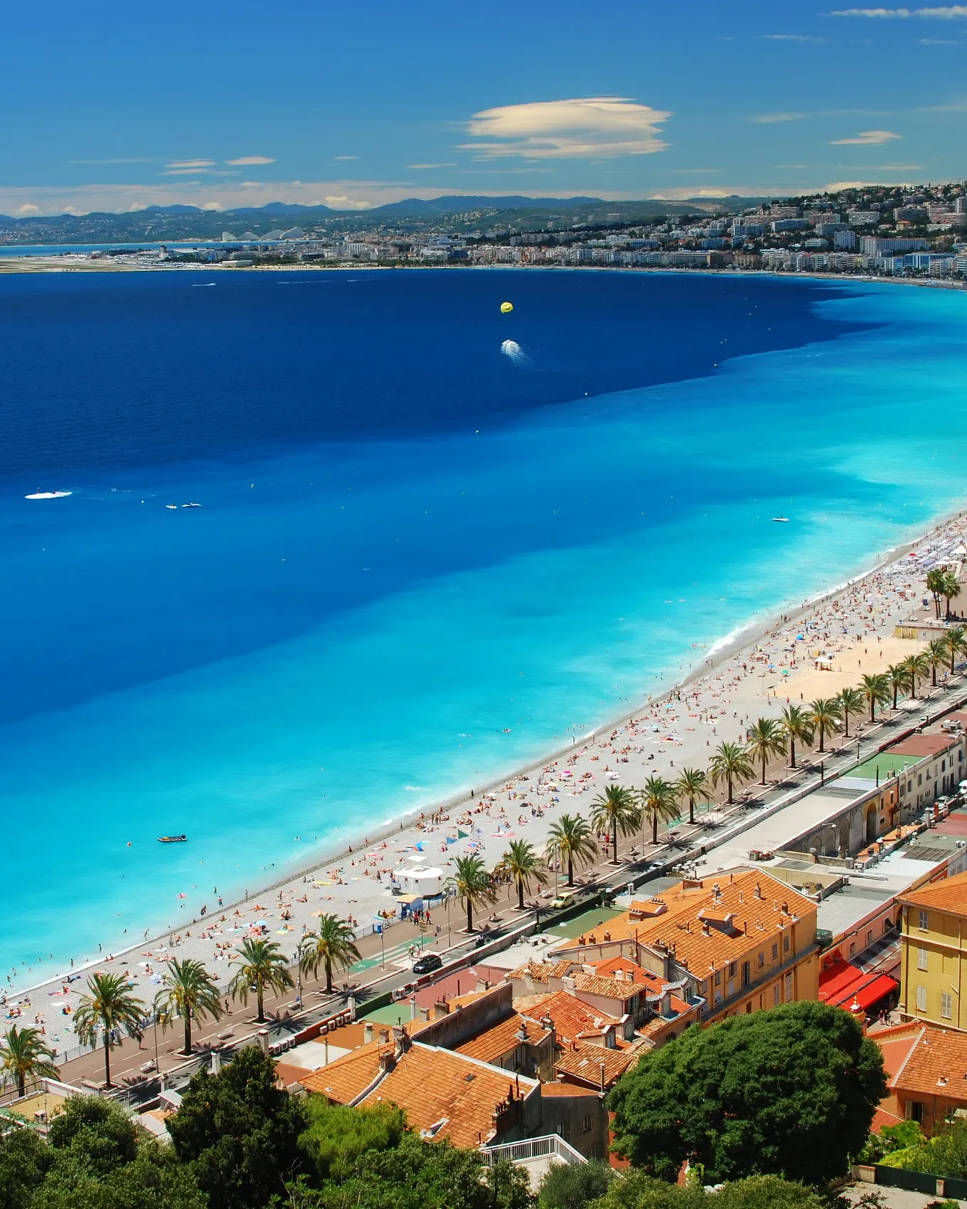 La baie des Anges et la plage de Nice vues des hauteurs de la colline du Château, la promenade des Anglais et ses palmiers