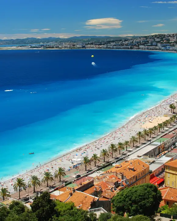 The Baie des Anges and the beach of Nice seen from the Castle Hill, the Promenade des Anglais and its palm trees