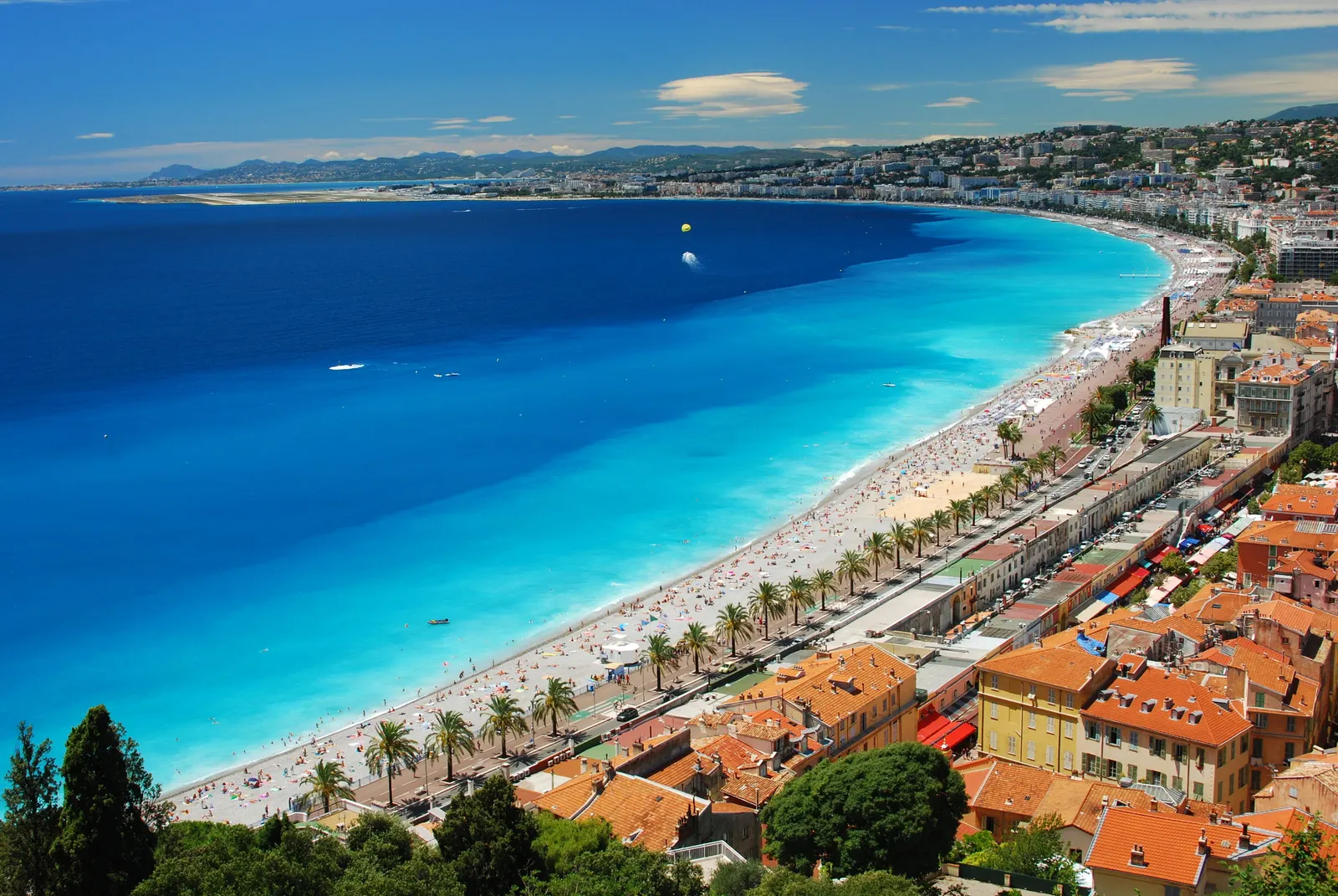 The Baie des Anges and the beach of Nice seen from the Castle Hill, the Promenade des Anglais and its palm trees