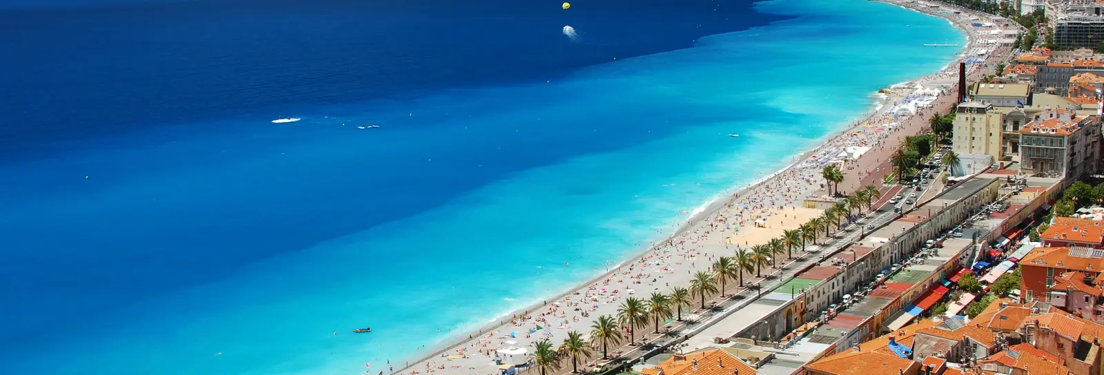 La baie des Anges et la plage de Nice vues des hauteurs de la colline du Château, la promenade des Anglais et ses palmiers